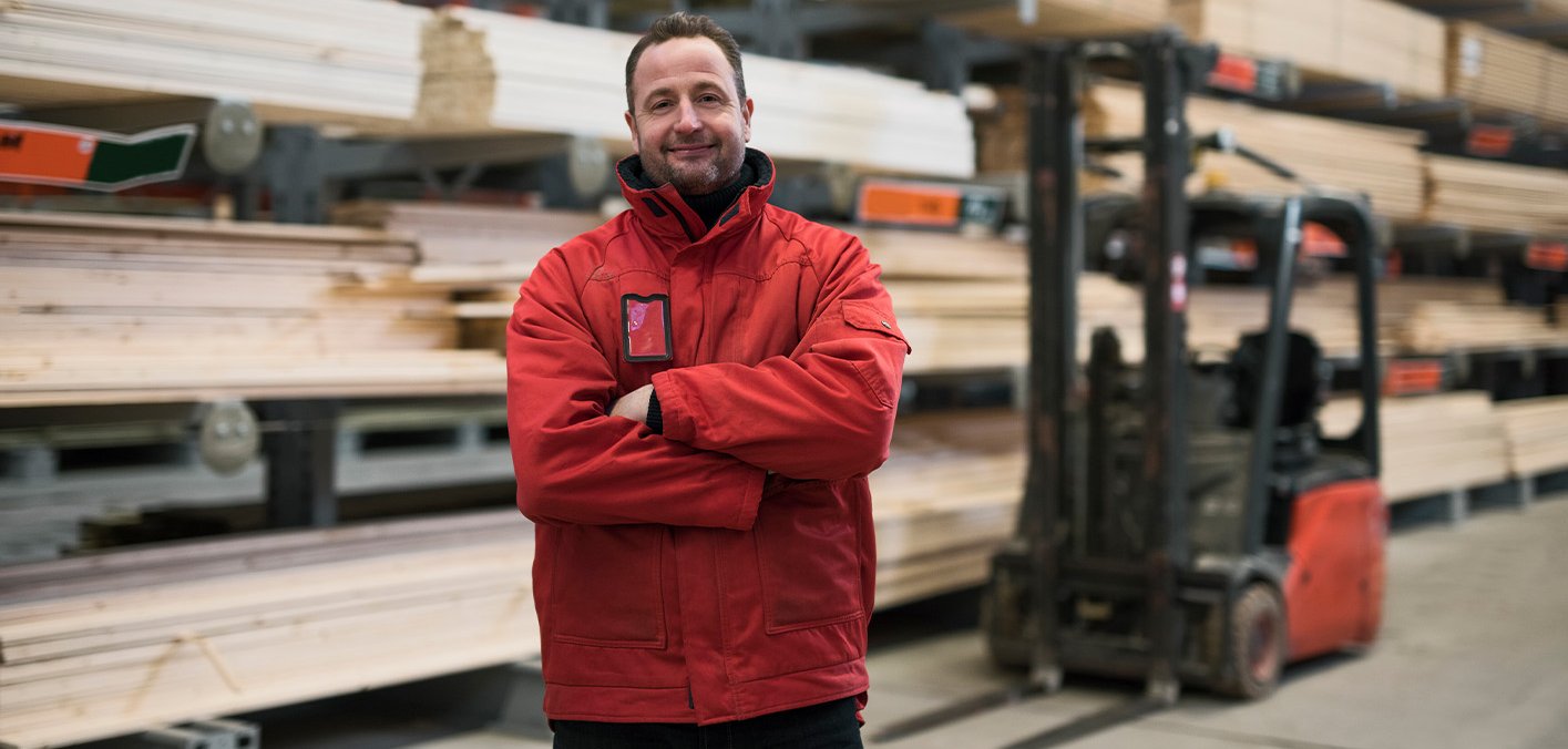 Wir beraten Sie gern, sprechen Sie uns an! Freundlicher Mitarbeiter im Holzlager